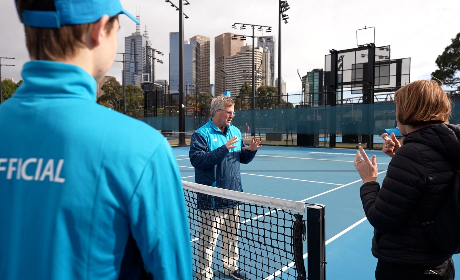 Male chair umpire signing to AusOpen staff at the Deaf and Hard of Hearing tournament