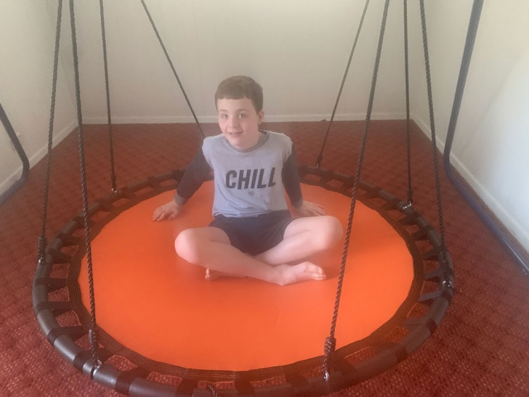 Charlie sits on his orange trampoline