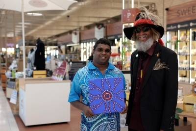 Travis showing off his art with Yuandamarra at the airport.