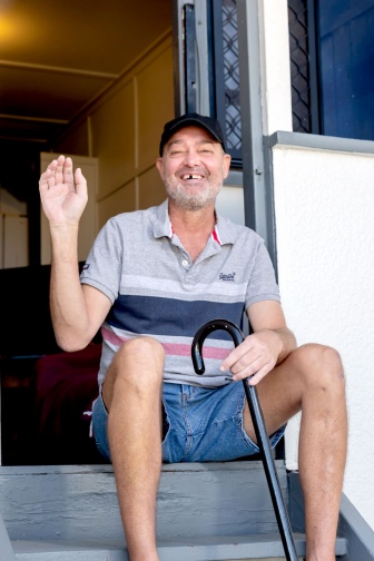 Bill Nolles smiles and waves from his front step