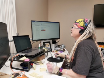 A woman is sitting at desk working on a computer