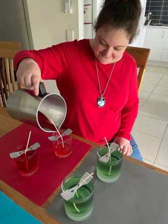 Marisa wearing a red top and pouring 4 candles