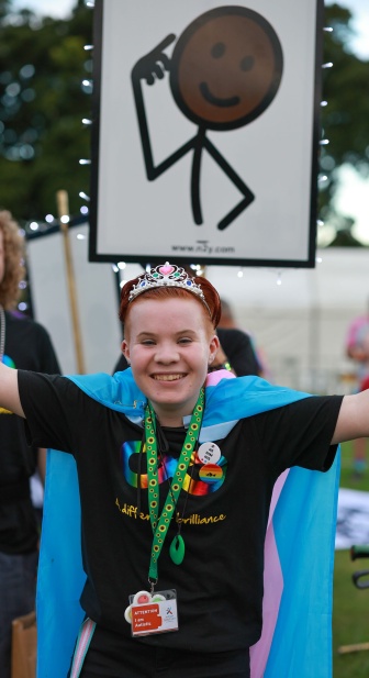 Aspen in a parade wearing a cape and crown smiling