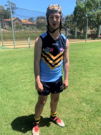 Benson standing on a football pitch, wearing his blue and yellow Temora Kangaroos football uniform