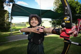 Janelle Colquhoun with bow at archery range 