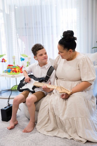 Greyson playing the guitar.