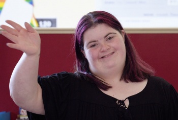 NDIS participant Victoria smiling and waving at the camera