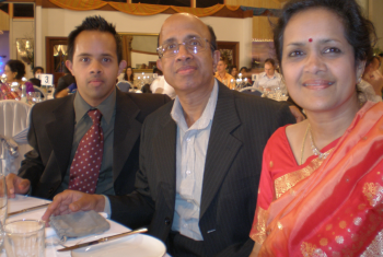 Male NDIS participant in his 30s' sitting next to his dad and mum at a dinner.