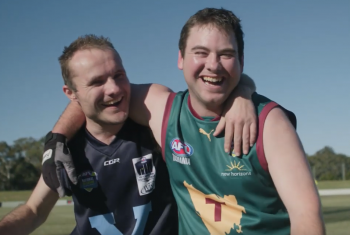 AFL National Inclusion Carnival Players smile arm in arm for an on field photo