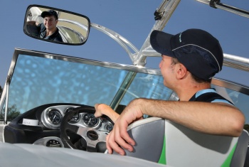 Stefan sits in the driver's seat of his speedboat and looks into the mirror