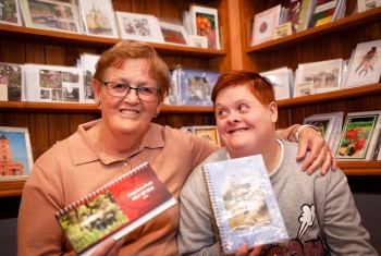 Trish has her arm around her daughter, Kez, who is holding one of the notebooks in her stationery range