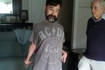 Adam standing with father Brian, looking at camera