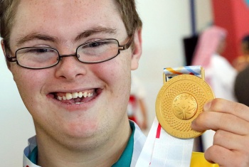 Charlie holding a gold medal for swimming.