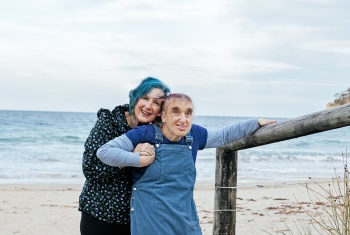 Edie Batemans and Sue Novak hugging at the beach.