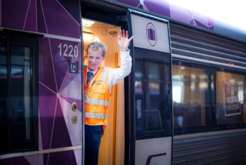 Henry John waving from a train carriage 