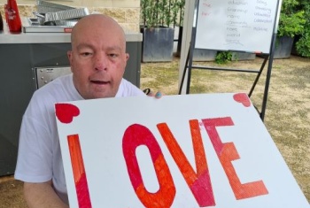 Andrew Bryson with a sign saying love