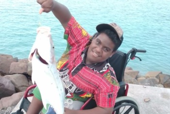 Charlie Kris with a big fish caught on a wharf.